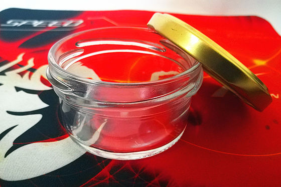 Un pot de caviar en verre très transparent avec un couvercle métallique