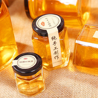 Bouteille de stockage en verre transparent hexagonal 100 ml 500 ml avec couvercle métallique pour la crème de miel